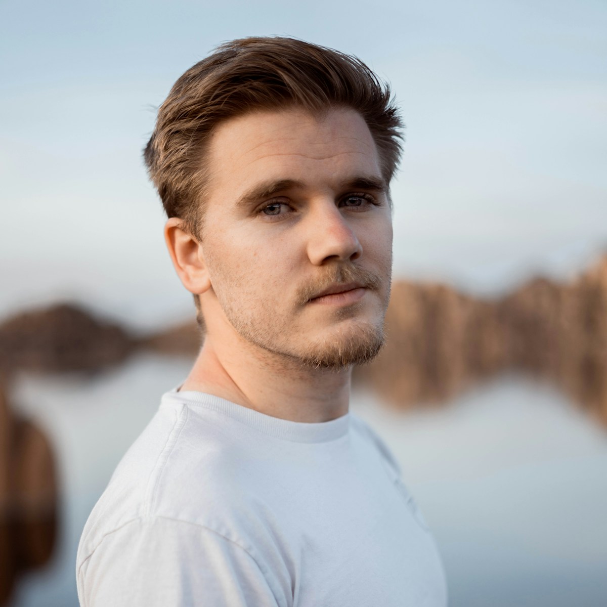 a man standing in front of a body of water